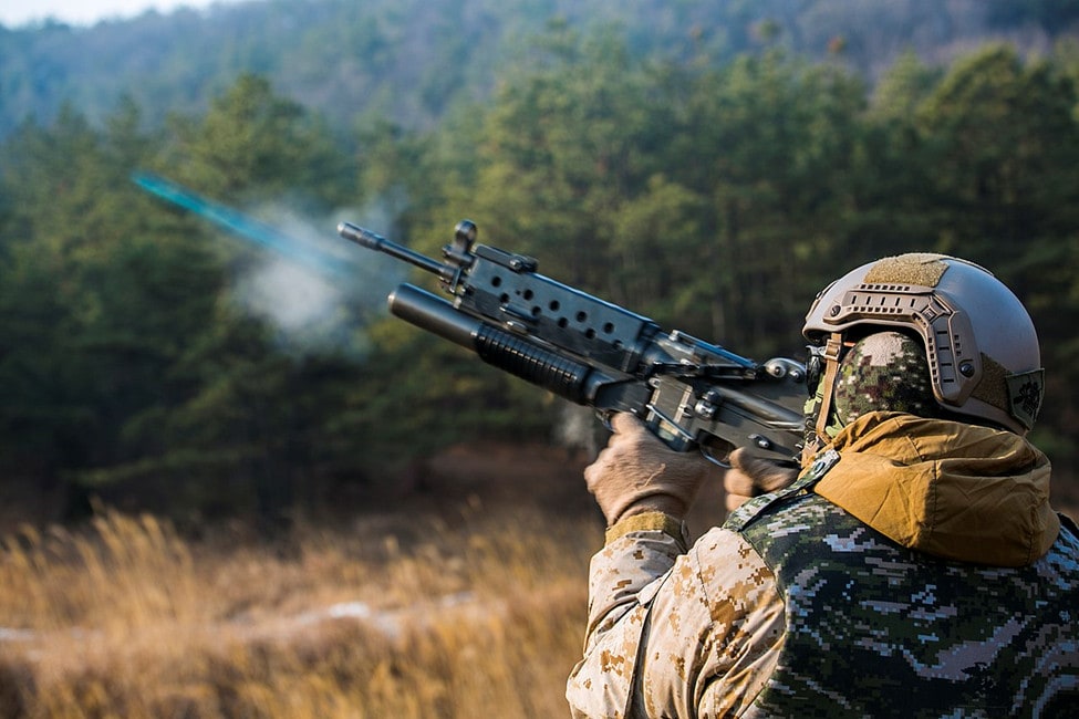 Soldier in camo firing an M203.