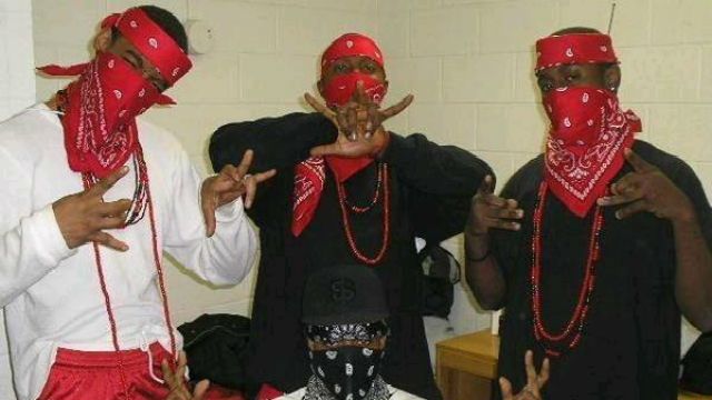 Blood gang signs: Another example of Blood attire. Note the red bandanas and necklaces, both signature elements of Blood style. 