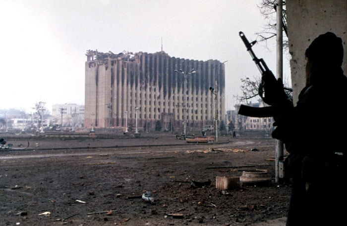 Fighter looking at bombed out building.