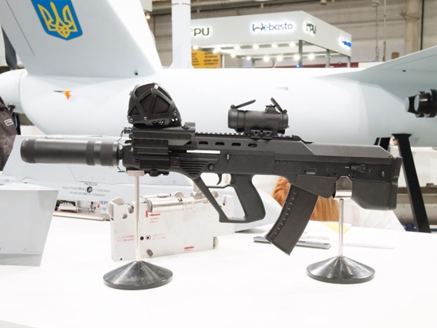 Bullpup rifle with Ukrainian drone in background.