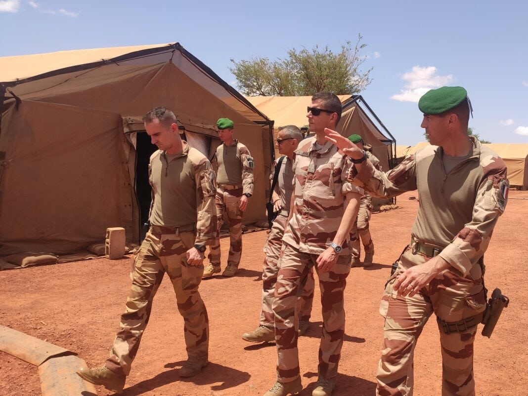 Several members of the Barkhane Force walking through the Projected Air Base (BAP) of Nimey on the Sahel region strip.