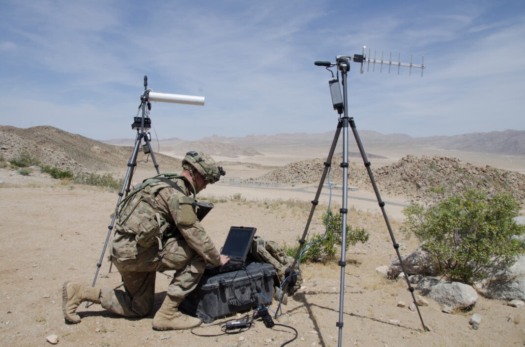 Pfc. Nathaniel Ortiz of the 780th Military Intelligence Brigade sets up deployable cyber tools overlooking the mock city of Razish at the National Training Center at Fort Irwin, Calif.
