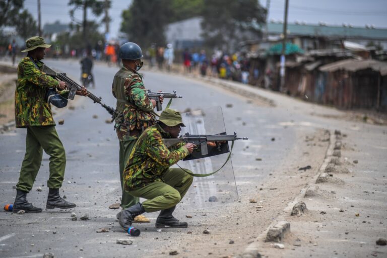 Image shows 3 security personnel intervening at protests in Nairobi, Kenya