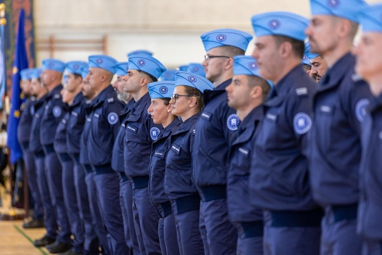 Image shows a line of Frontex Standing corps personnel. The members are dressed in navy blue uniforms. 