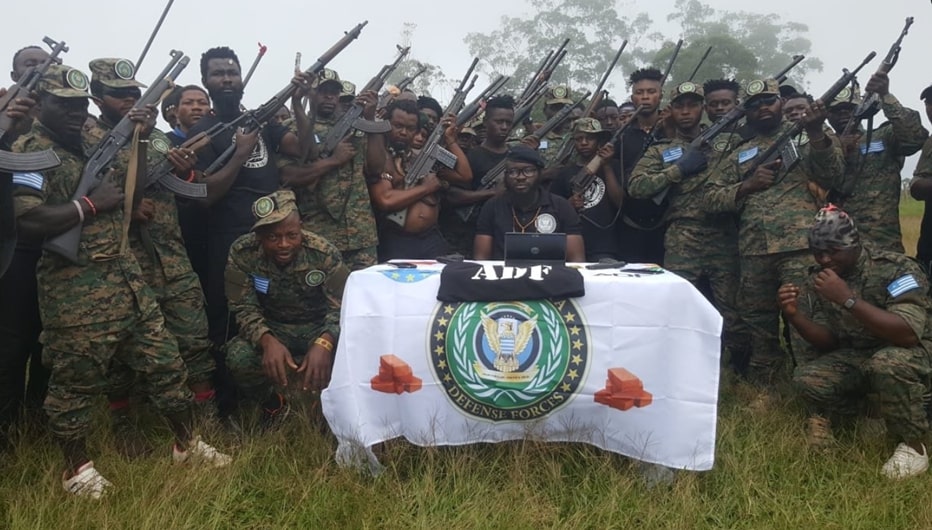 A piece of ADF propganda. ADF combatants are photographed holding weapons. They are wearing military-style uniforms with either breast patches or epaulettes  of the Ambazonian flag 