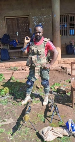 An ADF solider posing with seized military gear and weapons