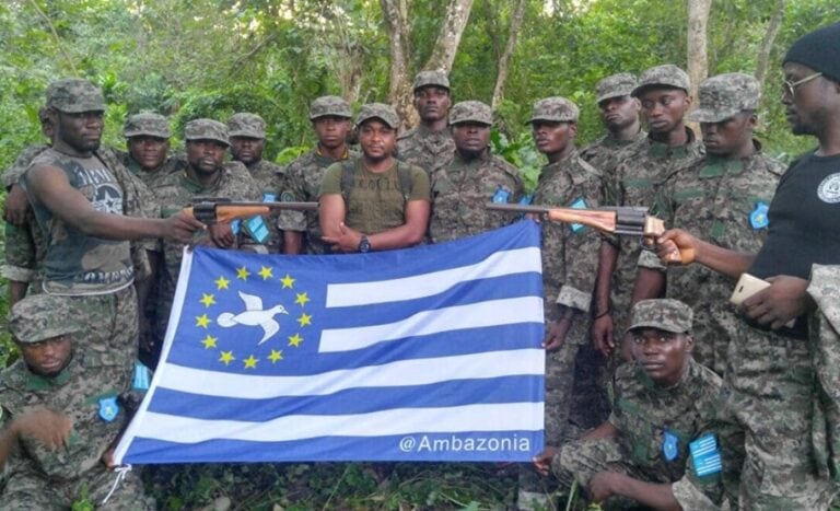 Ambazonia Defence Force troops pose for a photograph, brandishing the Ambazonian flag