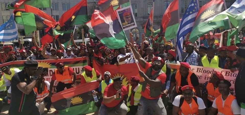 IPOB supporters rallying for Biafran independence. They are seen brandishing Biafran and Ambazonian flags, with photos of Nmandi Kanu (IPOB's detained leader).