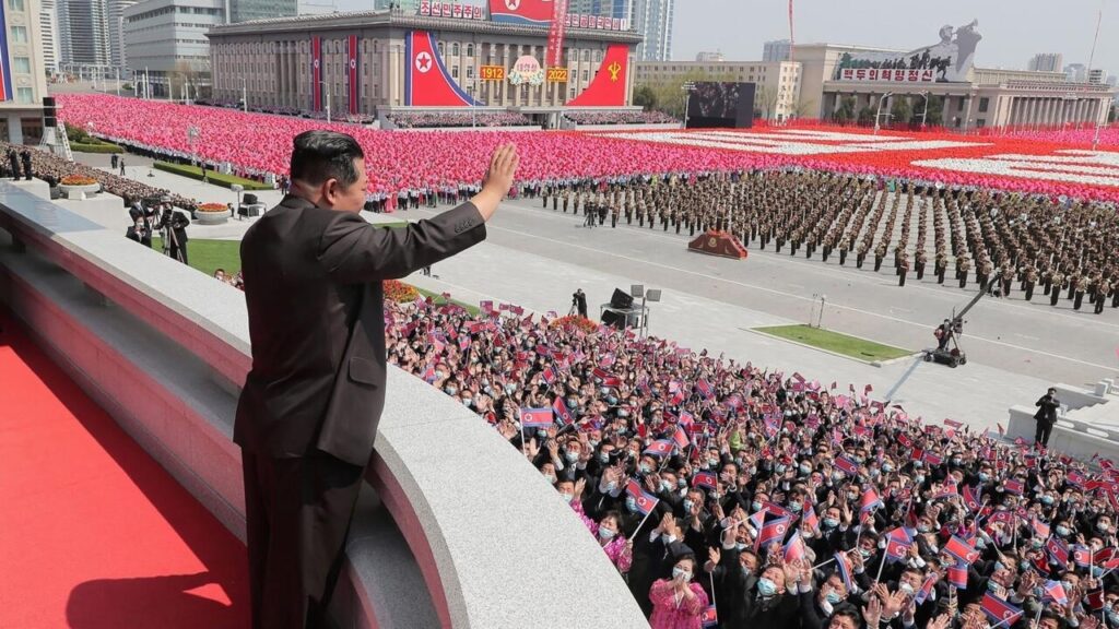 Kim Jong Un waving at onlookers in the DPRK