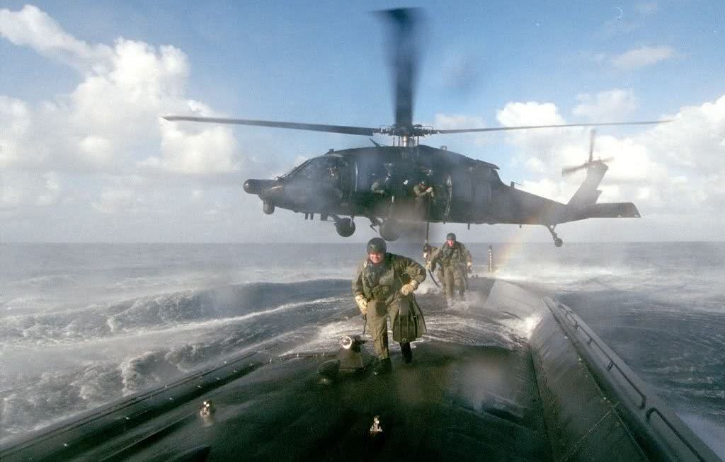 Black Hawk dropping off Green Berets onto a submarine in the water.