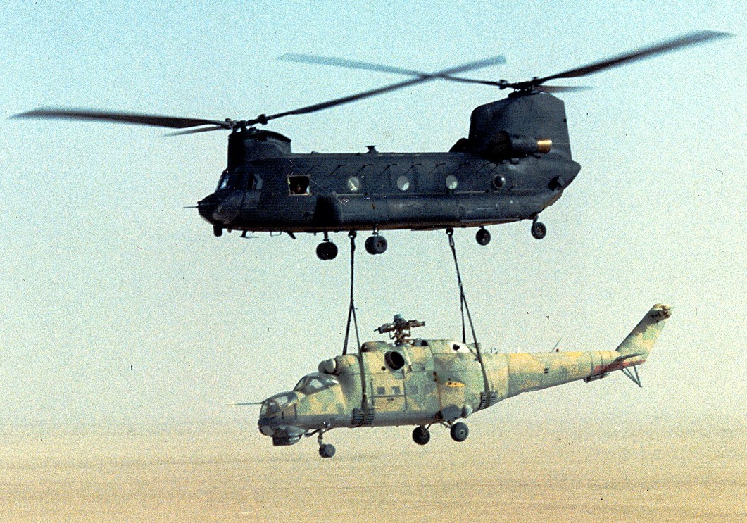 Chinook transporting a Hind helicopter via sling load.