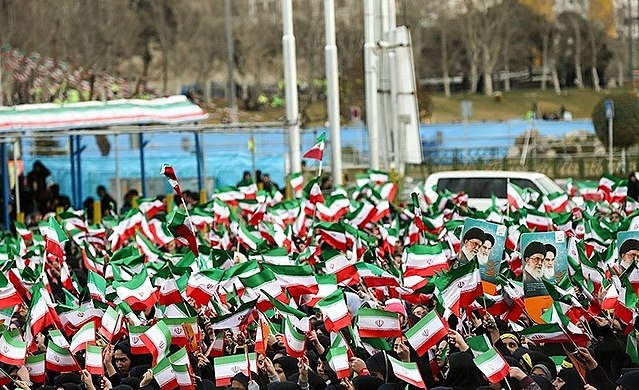 Crowds waving Iranian flags.