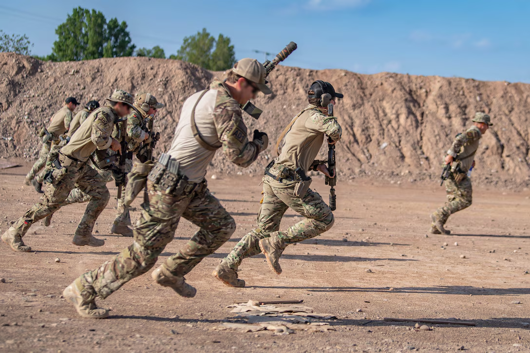 Group of soldiers running in a desert with weapons.
