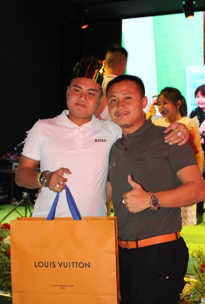 The two sons of Saw Chit Thu are pictured posing alongside designed merchandise. The two are active members of the KNA business and engage in military operations.
