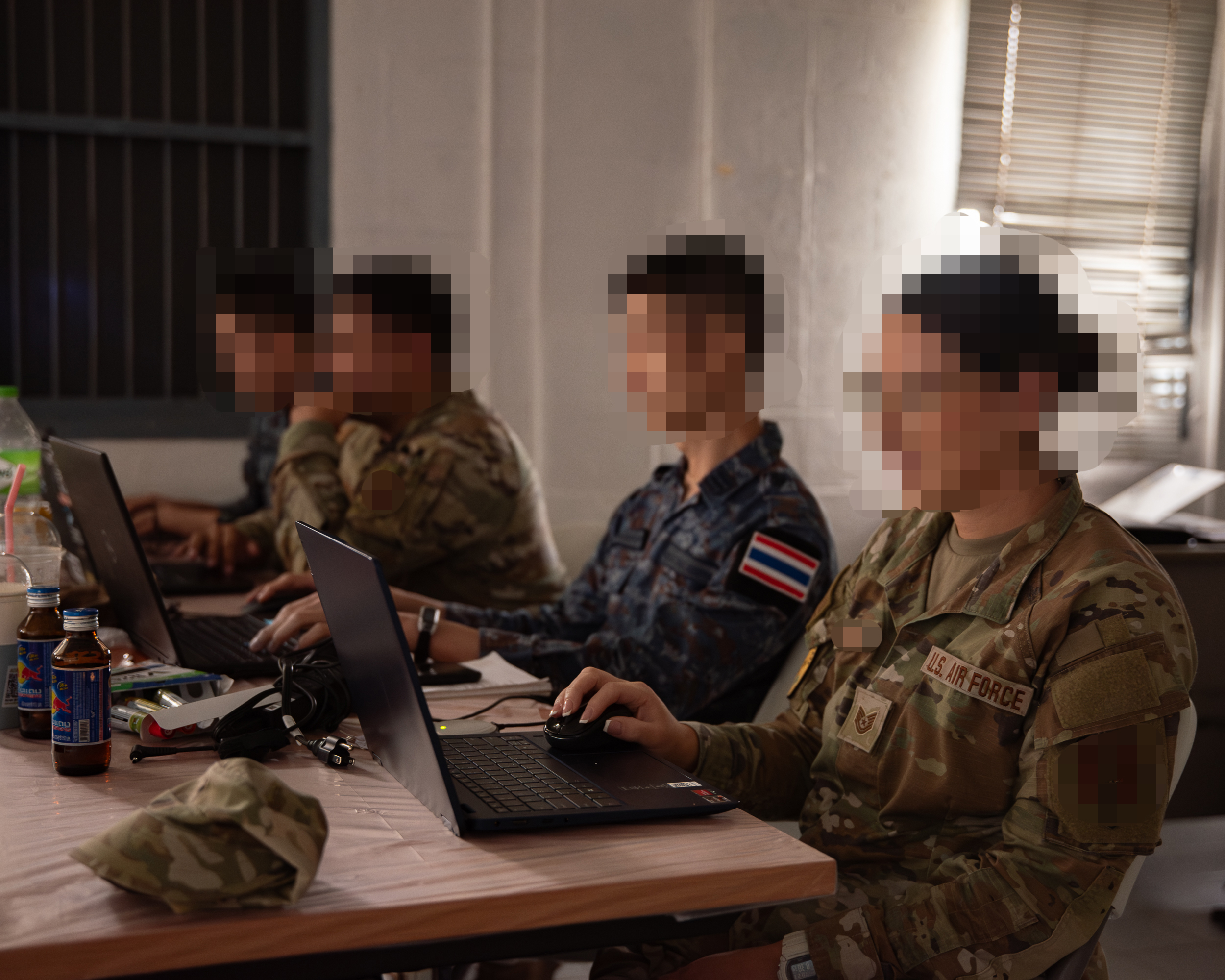 U.S. Air Force and Royal Thai Air Force intelligence analysts work side by side at laptops during the Enduring Partners exercise at Korat, Thailand.