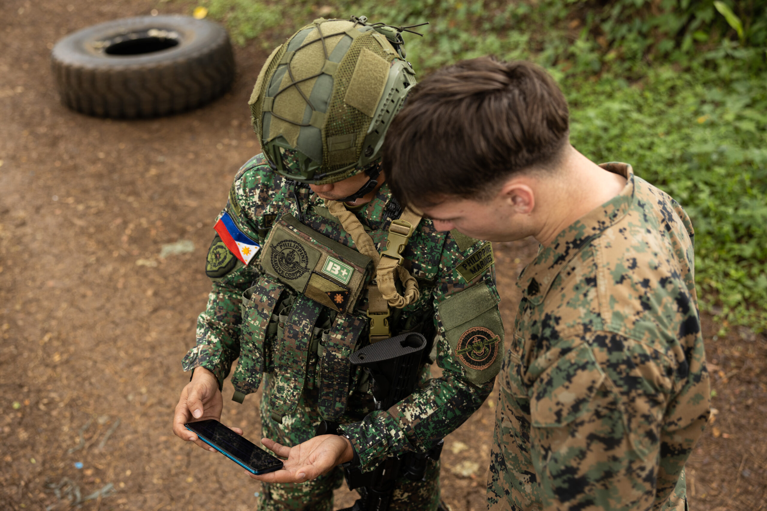 A U.S. Marine shows a Philippine marine how to use a tactical app on a smartphone during the combined KAMANDAG 10 exercise in the Philippines.